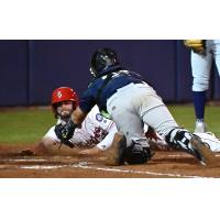 Spokane Indians try to score on a play at the plate against the Tri-City Dust Devils