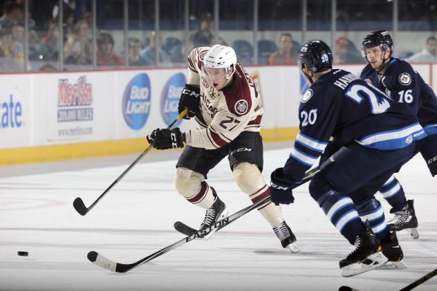 Jordan Caron of the Chicago Wolves Tries to Control the Puck vs. the Manitoba Moose