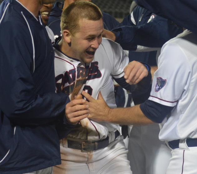 of the Somerset Patriots Mobbed by Teammates after Scoring on Wild Pitch