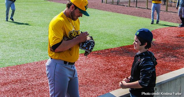 Normal CornBelters sign autographs for a young fan