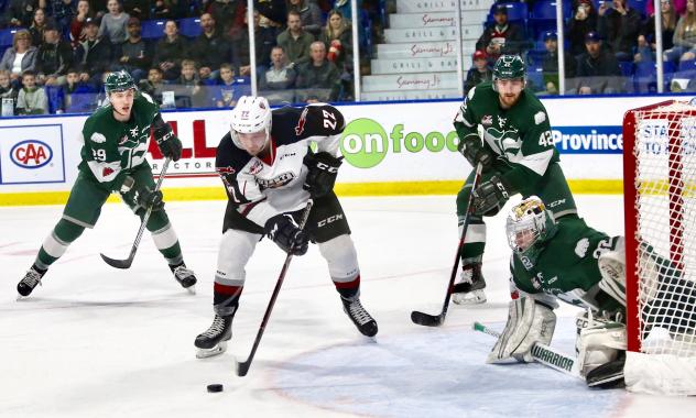 Vancouver Giants control the puck in front of the Everett Silvertips goal