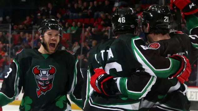 Binghamton Devils celebrate a goal in St. Patrick's jerseys