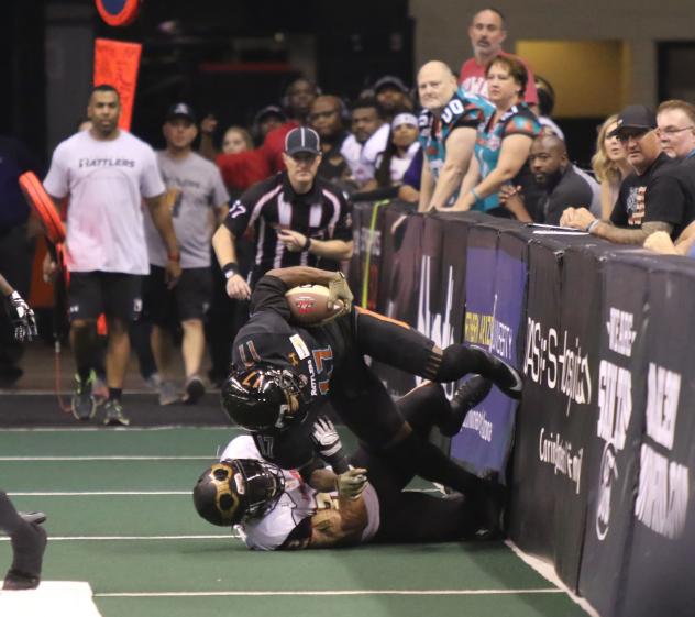 Dezmon Epps of the Arizona Rattlers is tackled along the boards by a member of the Iowa Barnstormers