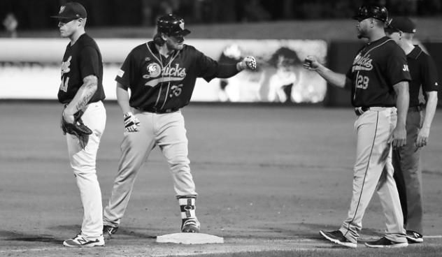 Taylor Ard of the Long Island Ducks gives a fist bump at third base
