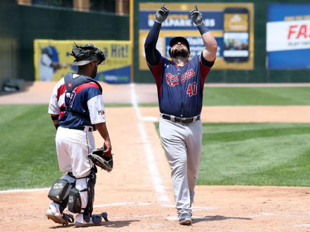 Kyle Roller of the Somerset Patriots points skyward as he crosses home plate