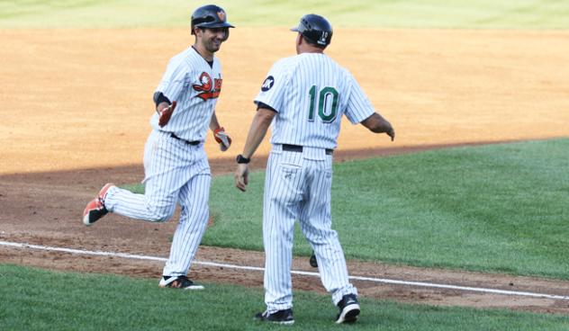 Dan Lyons of the Long Island Ducks receives a high five while rounding third