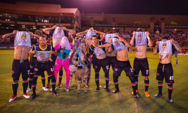 Las Vegas Lights FC's Starting XI poses with the emoji on the underside of its home kits