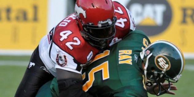Mike Labinjo of the Calgary Stampeders sacks Edmonton Eskimos quarterback Ricky Ray