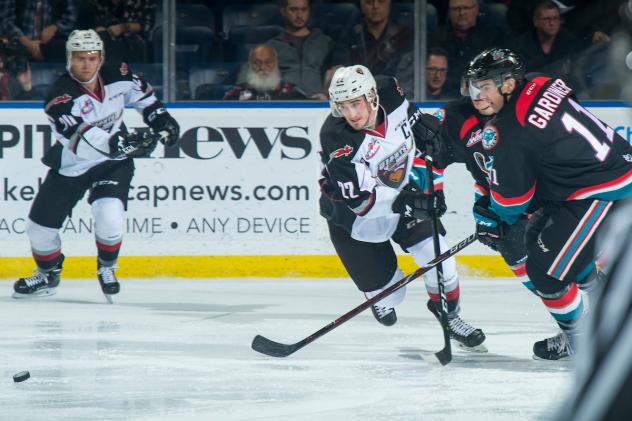 The Kelowna Rockets and Vancouver Giants chase after a loose puck