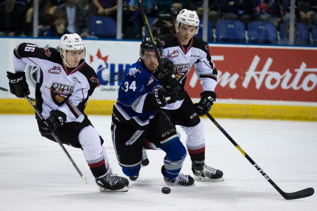 Davis Koch of the Vancouver Giants (left) vies for the puck vs. the Victoria Royals