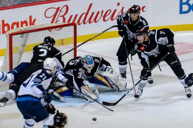 The Manitoba Moose and San Antonio Rampage scramble in front of the Rampage net