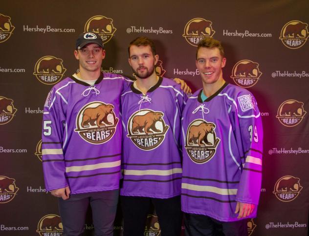 Colby Williams, Riley Barber and Logan Pyett of the Hershey Bears show off the team's Hockey Fights Cancer jerseys