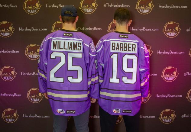 Colby Williams and Riley Barber of the Hershey Bears show off the team's Hockey Fights Cancer jerseys
