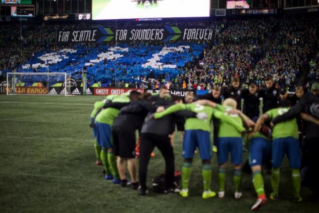 Seattle Sounders FC huddle in front of the Seattle crowd