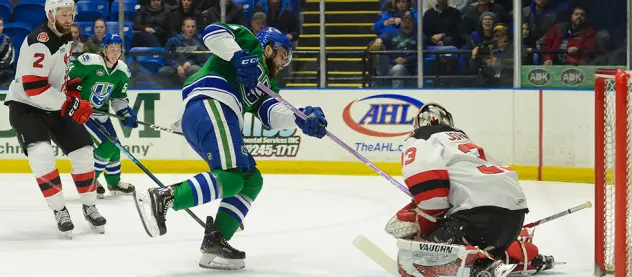 Binghamton Devils goaltender Cam Johnson stops a Utica Comets' shot