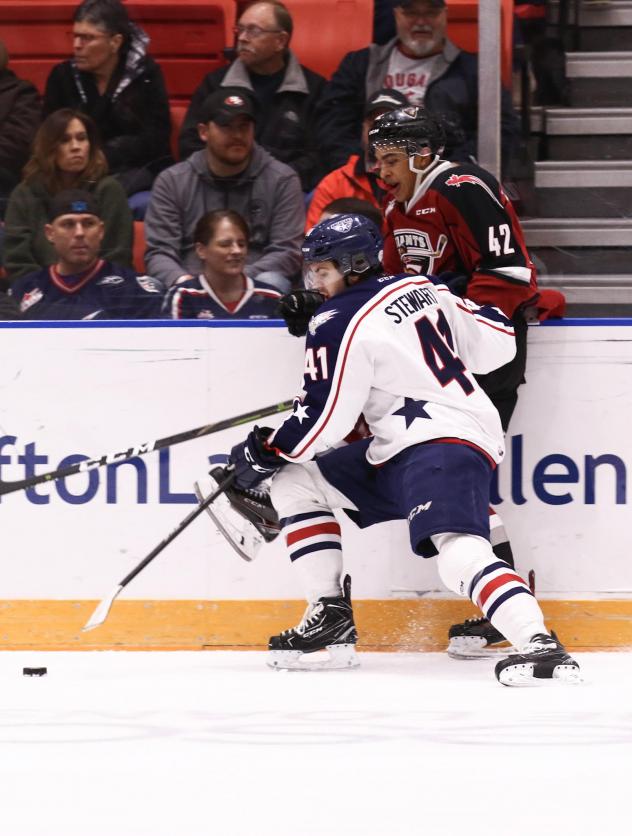 Vancouver Giants centre Justin Sourdif (right) against the boards vs. the Tri-City Americans