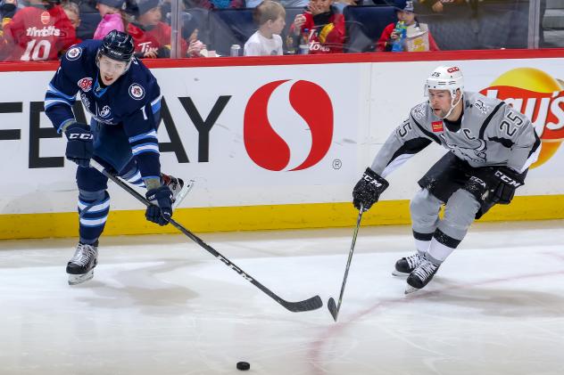 San Antonio Rampage captain Chris Butler (right) challenges Manitoba's Logan Stanley