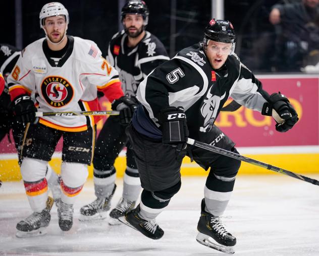 Tyler Wotherspoon of the San Antonio Rampage races for a puck with the Stockton Heat's Andrew Mangiapane