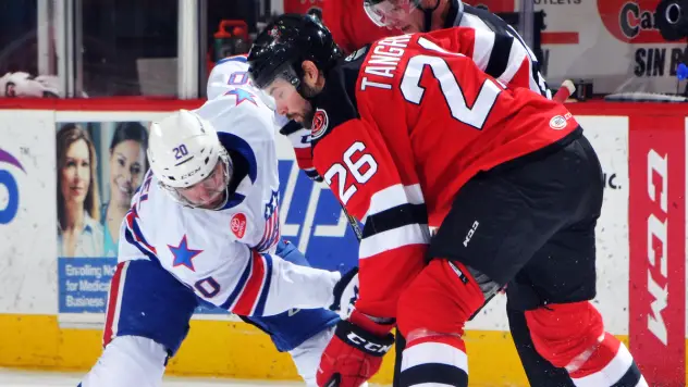 Eric Tangradi of the Binghamton Devils (right) faces off against the Rochester Americans