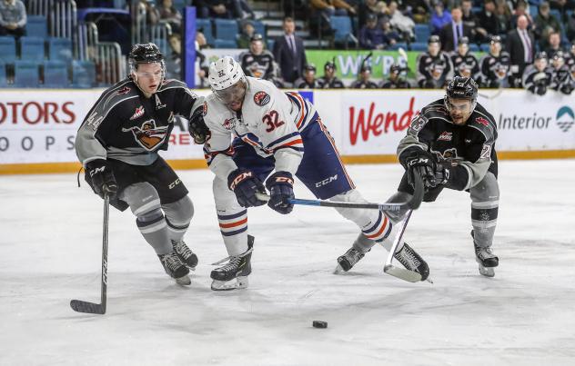 Vancouver Giants defenceman Bowen Byram (left) and centre Jadon Joseph (right) harass a Kamloops Blazer