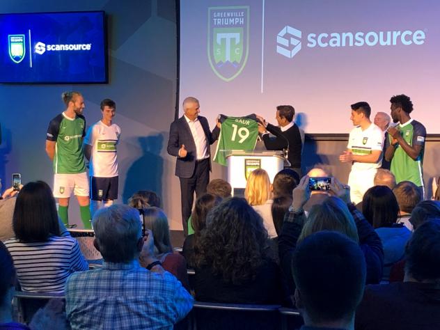 Greenville Triumph Head Coach John Harkes presents Scansource CEO Mike Bauer with the team's new jersey