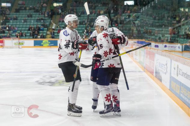 Prince George Cougars in their Don Cherry jerseys exchange congratulations after a goal against the Portland Winterhawks