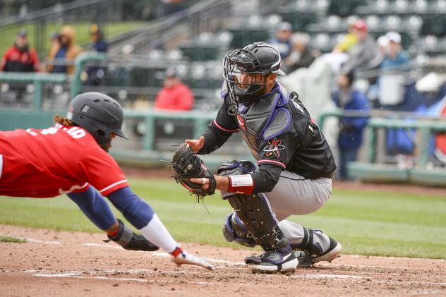 Eric Young, Jr. of the Tacoma Rainiers dives home against the Albuquerque Isotopes
