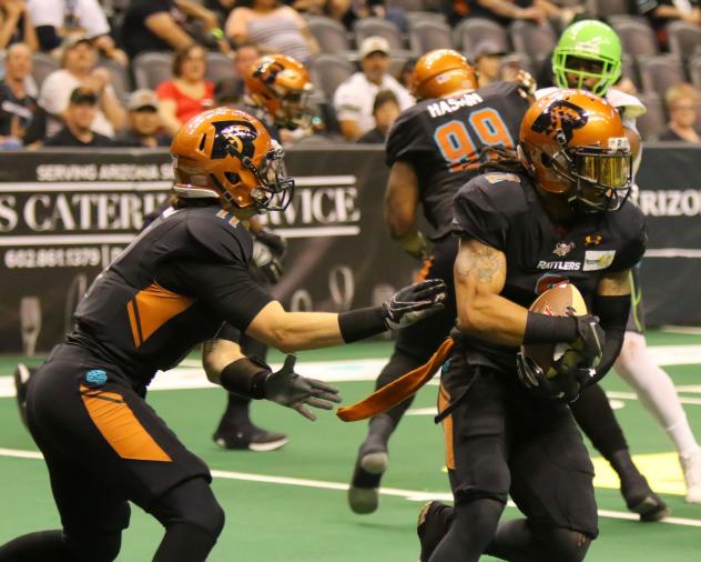 Arizona Rattlers quarterback Jeff Ziemba (left) hands the ball off