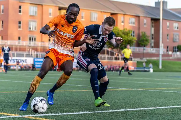 Lansing Ignite FC attacker Nathan Lewis (left) battles for possession