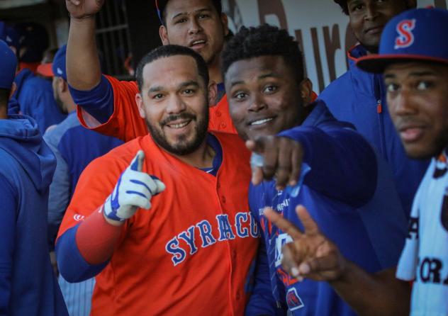 Rene Rivera celebrates in the Syracuse Mets dugout with his teammates after his first-inning home run on Friday night