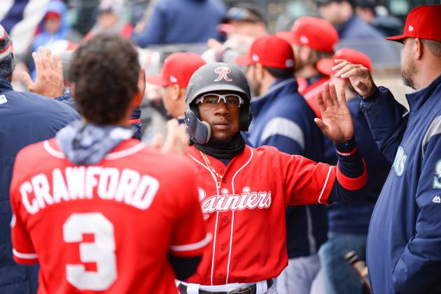 Shed Long of the Tacoma Rainiers receives congratulations in the dugout