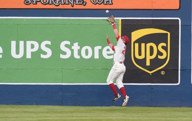 Spokane Indians leap for a catch at the wall