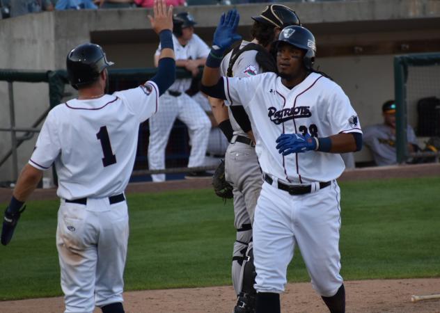 Jimmy Paredes of the Somerset Patriots receives a high five following his home run