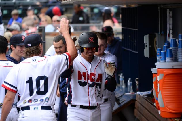 Jose Lobaton of the Tacoma Rainiers receives congratulations in the dugout