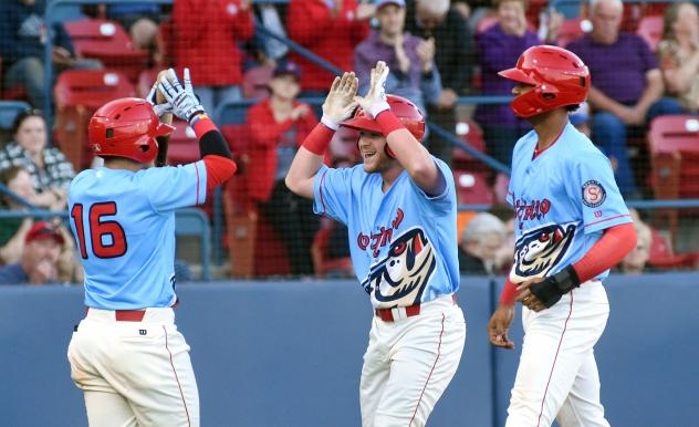 Blaine Crim of the Spokane Indians receives high fives after one of his home runs