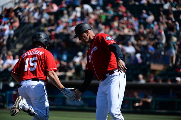Jaycob Brugman of the Tacoma Rainiers gets a low five as he rounds the bases