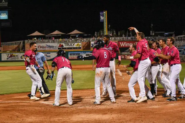 Mark Contreras of the Pensacola Blue Wahoos braces for his reception following his game-winning home run