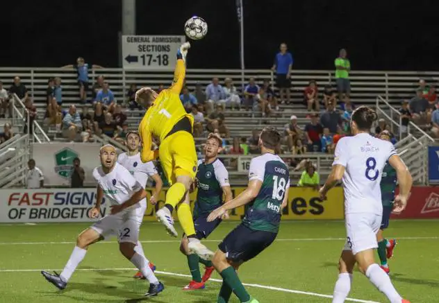 Memphis 901 FC goalkeeper Jeff Caldwell leaps high to swat a ball against Saint Louis FC