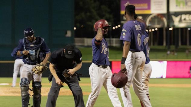 Frisco RoughRiders converse while the umpire examines his pants