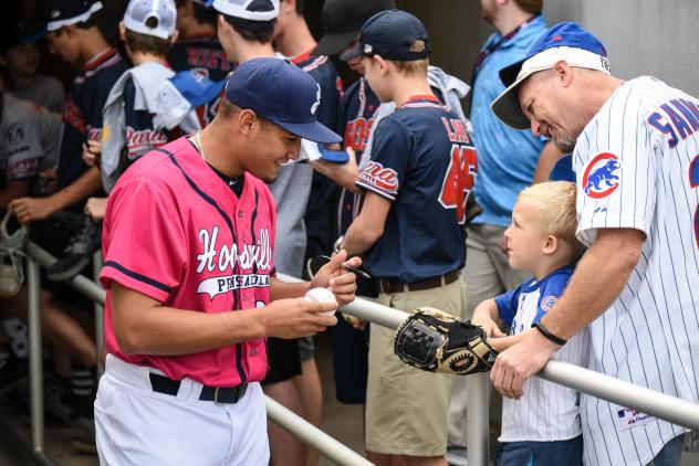 Jovani Moran of the Pensacola Blue Wahoos signs an autograph for a young fan