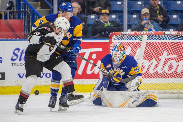 Vancouver Giants left wing Sergei Alkhimov (left) vs. the Saskatoon Blades