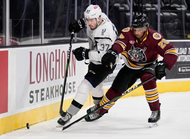 Jake Walman of the San Antonio Rampage (left) eyes the puck against the Chicago Wolves