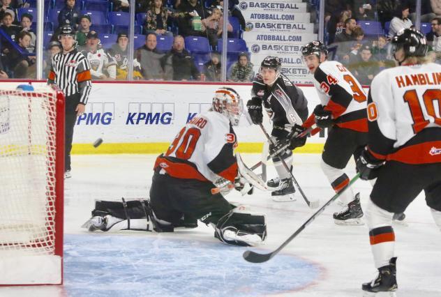 Vancouver Giants defenceman Dylan Plouffe (background) scores against the Medicine Hat Tigers