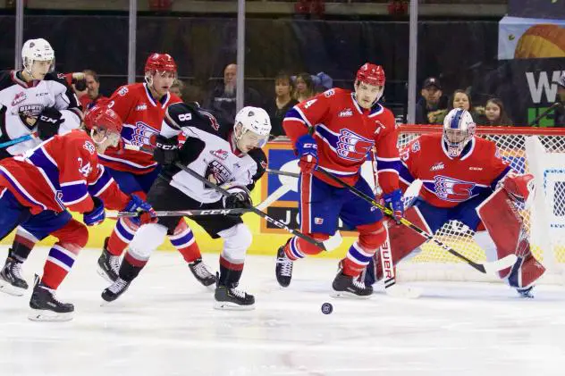 Vancouver Giants centre Tristen Nielsen (middle) eyes the puck against the Spokane Chiefs