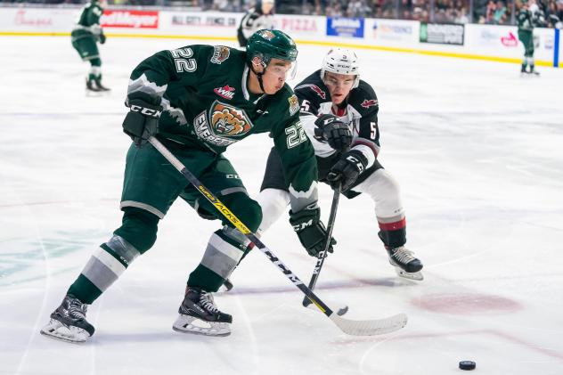 Vancouver Giants defenceman Jacob Gendron (right) tries to poke the puck away from the Everett Silvertips