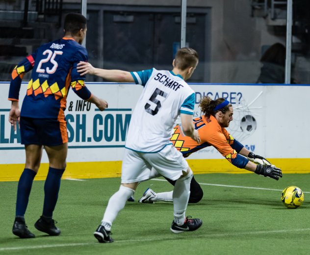 Tacoma Stars goalkeeper Danny Waltman scoops up a save as Mike Ramos battles St. Louis' Mike Scharf in front of the goal