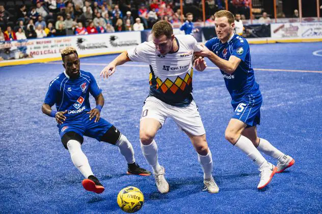 Nick Perers of the Tacoma Stars battles the Kansas City Comets' Kiel Williams (L) and Matt Lewis (R)