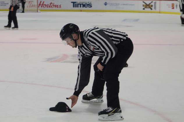 A WHL official collects a hat following Justin Sourdif's hat trick