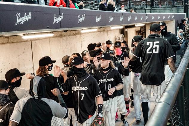 Milwaukee Milkmen exchange high fives in the dugout