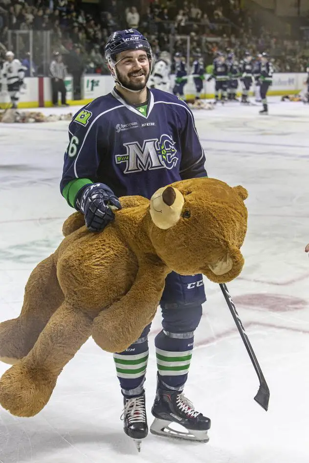 Morgan Adams-Moisan of the Maine Mariners helps remove bears from the ice after the Teddy Bear Toss